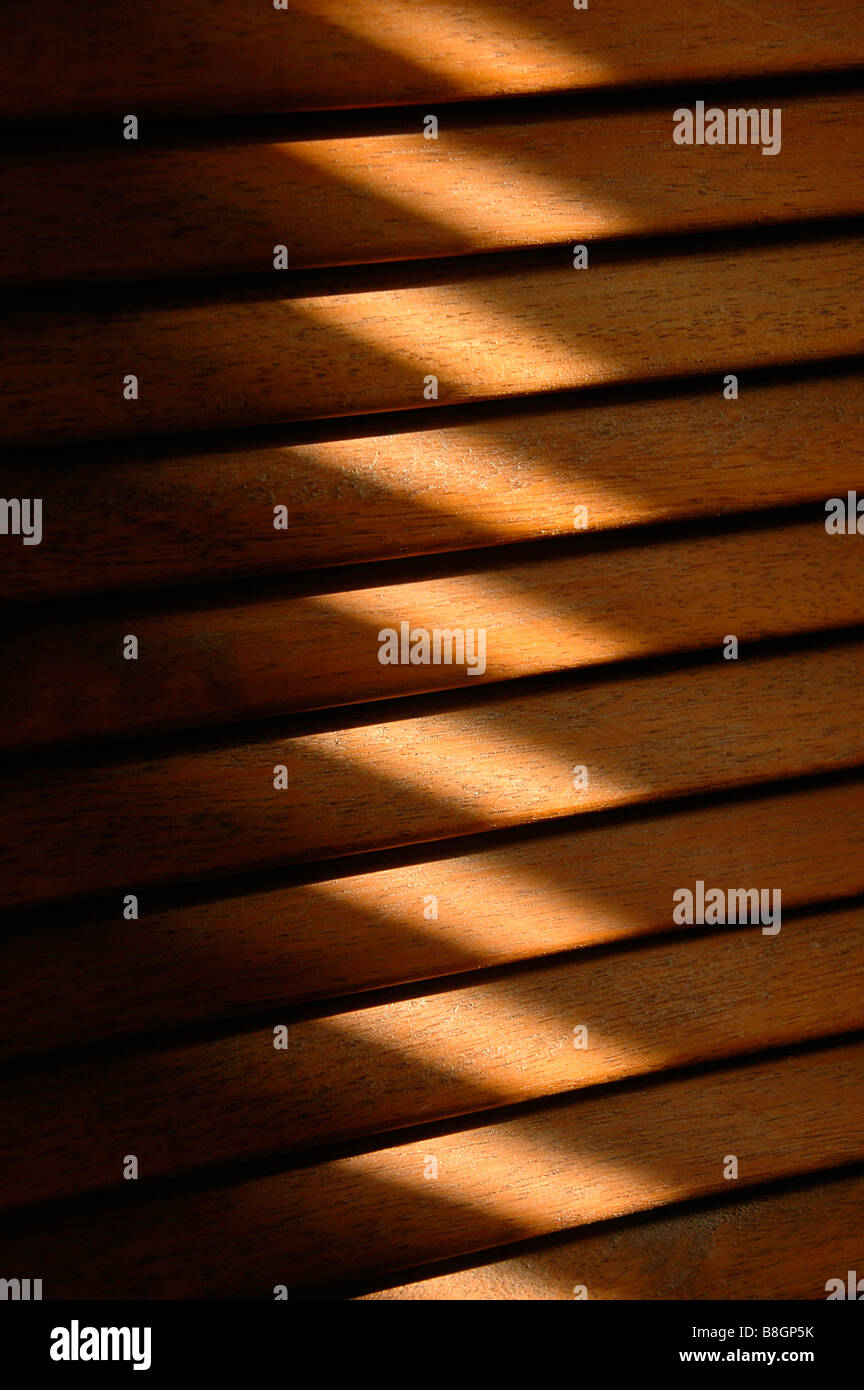 A strip of sunlight falling on a section of a wooden latticed door. Stock Photo
