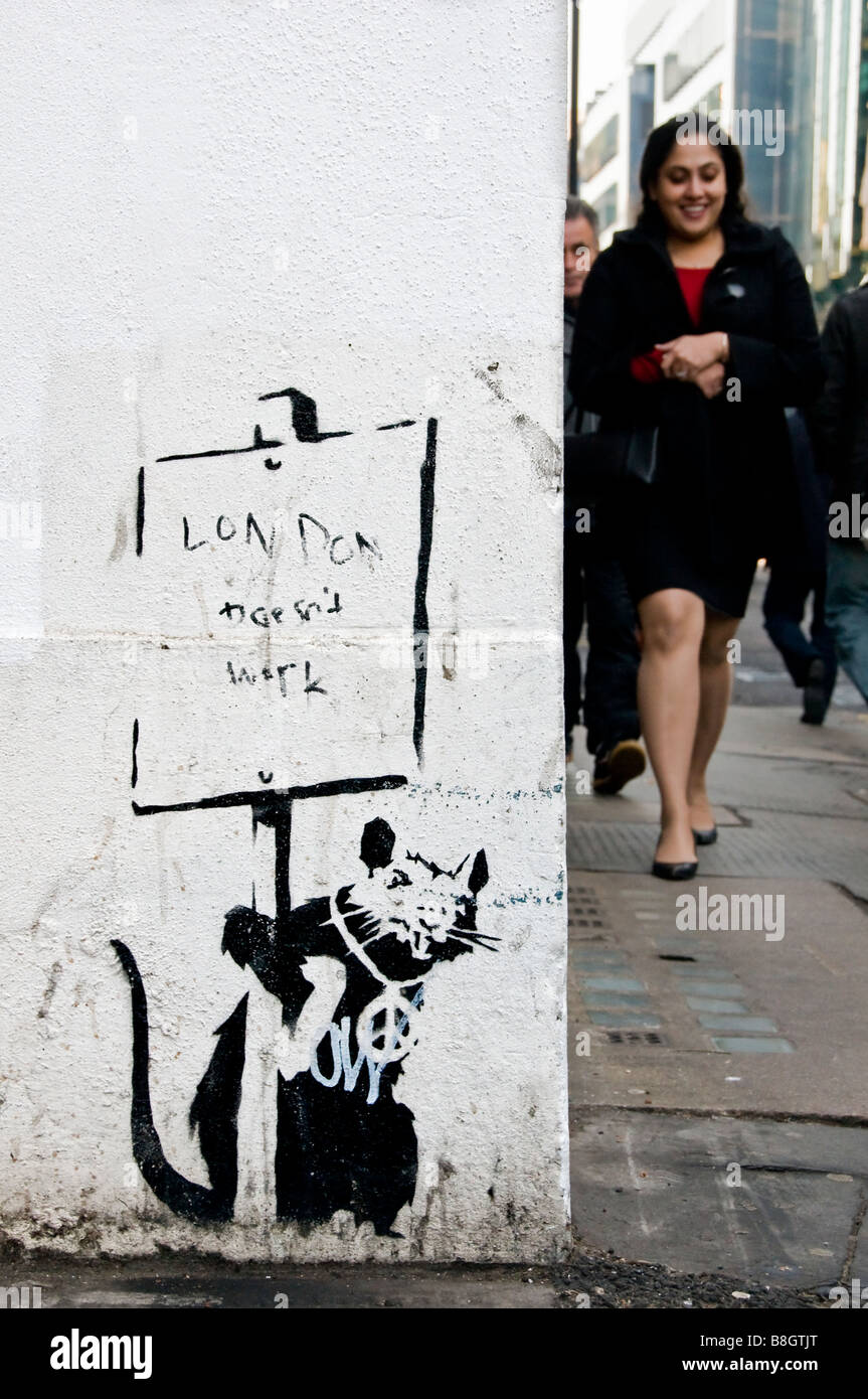 A business woman walking past Banksy 'London doesn't work' graffitti, The City of London, England, UK Stock Photo