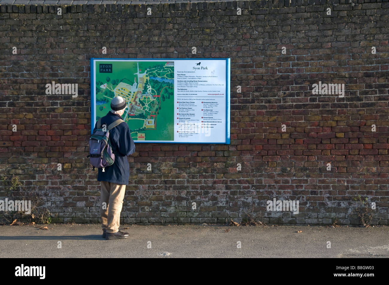 A tourist standing outside Syon House Park reading a map, Syon House Park, West London, Brentford, Middlesex, England Stock Photo