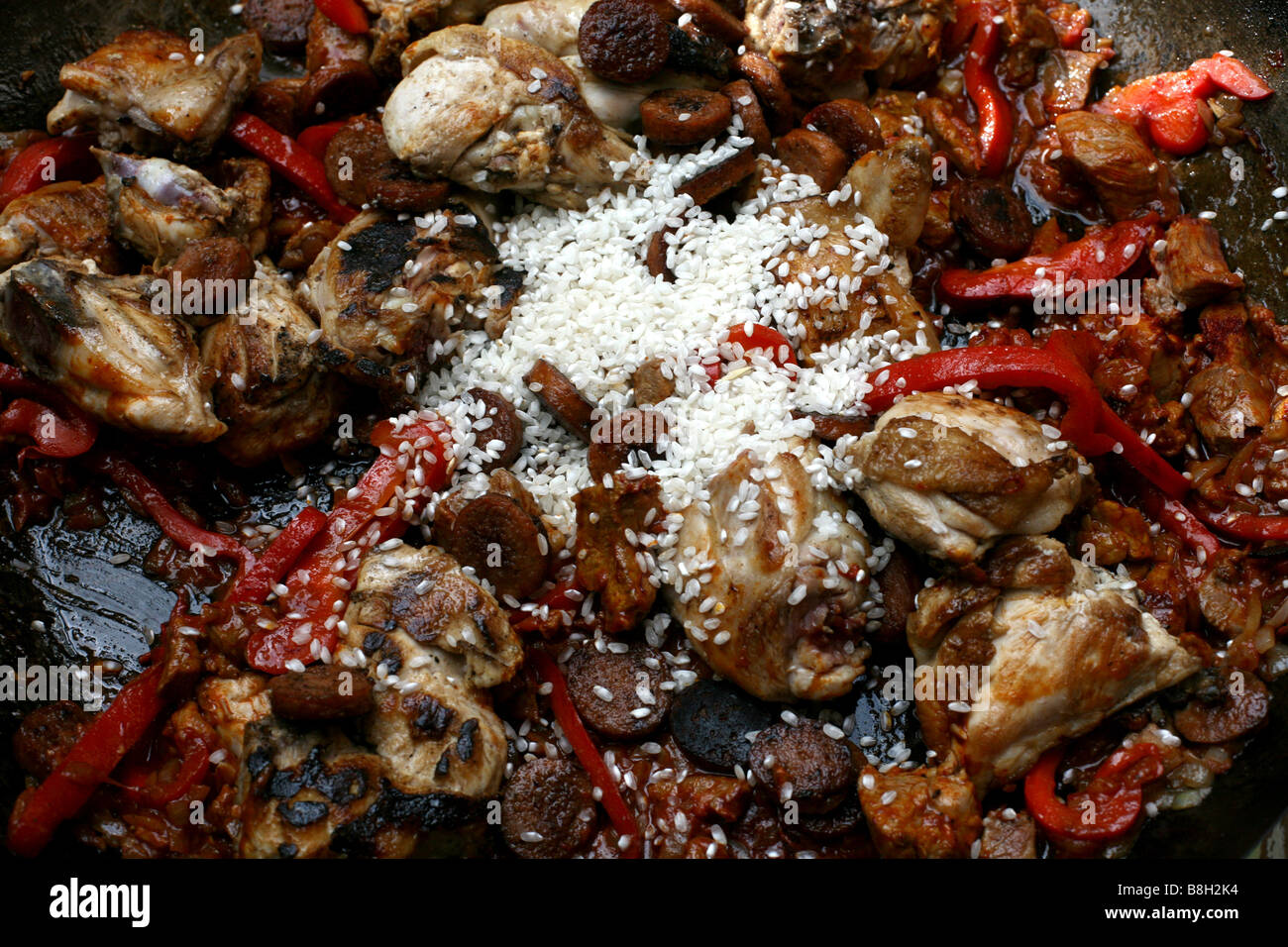 Aborio rice just after being added to a Paella Stock Photo - Alamy