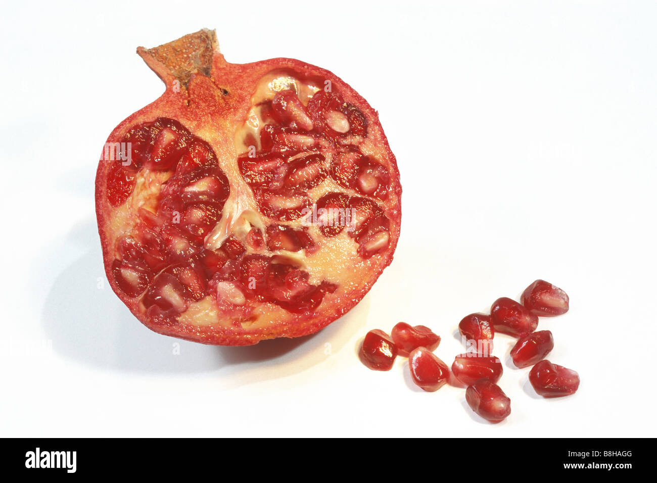 Pomegranate (Punica granatum), halved fruit and seeds, studio picture Stock Photo