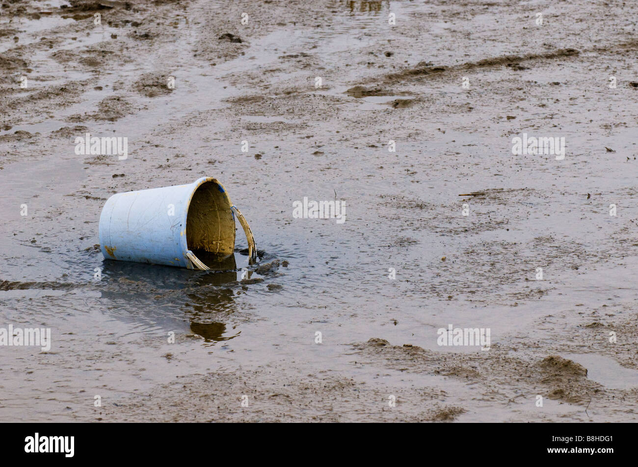 A plastic bucket partially submerged in the mud at Two Tree Island in Essex. Stock Photo