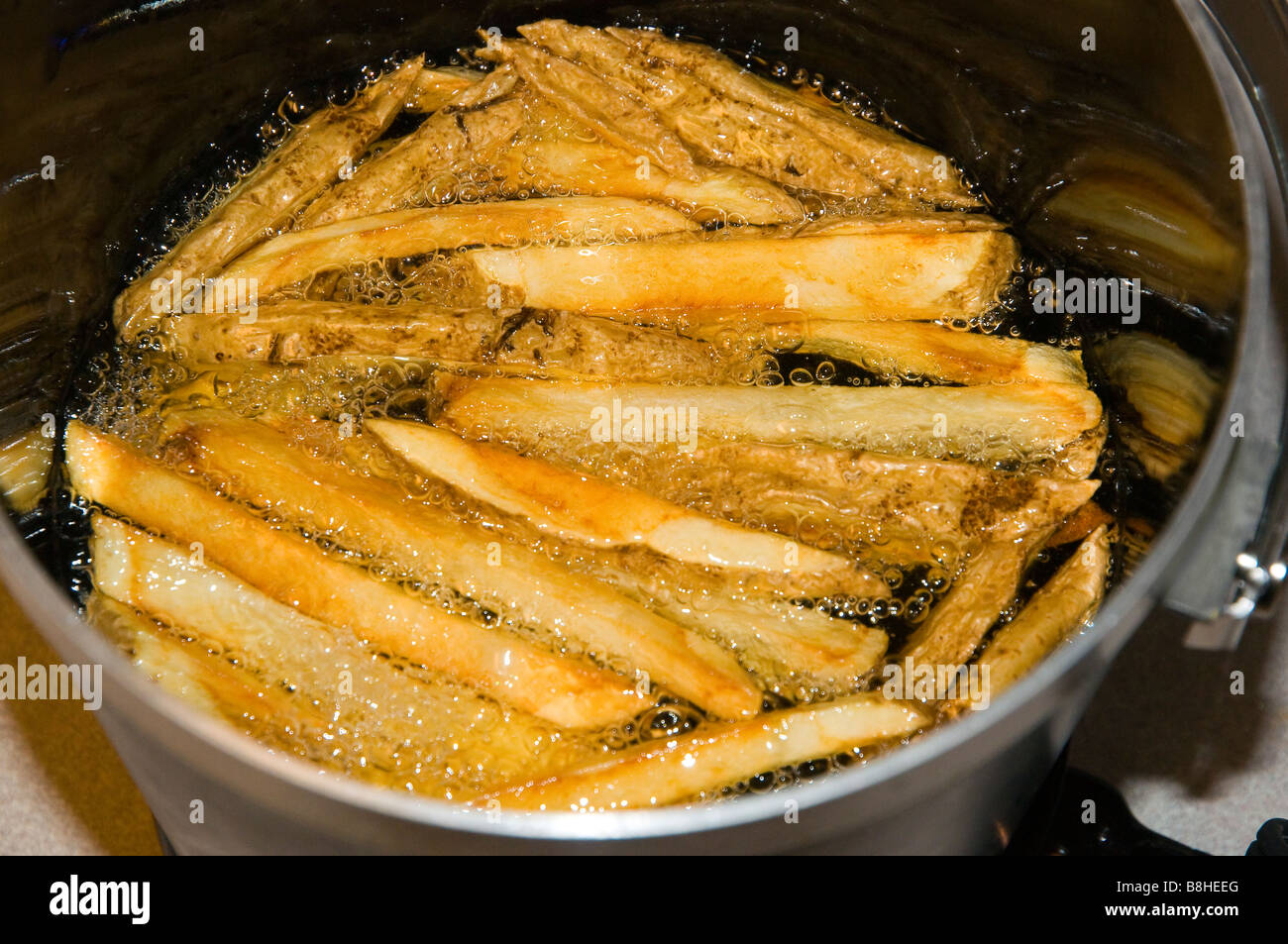 French Fries Cooking In Oil Stock Photo Alamy   French Fries Cooking In Oil B8HEEG 