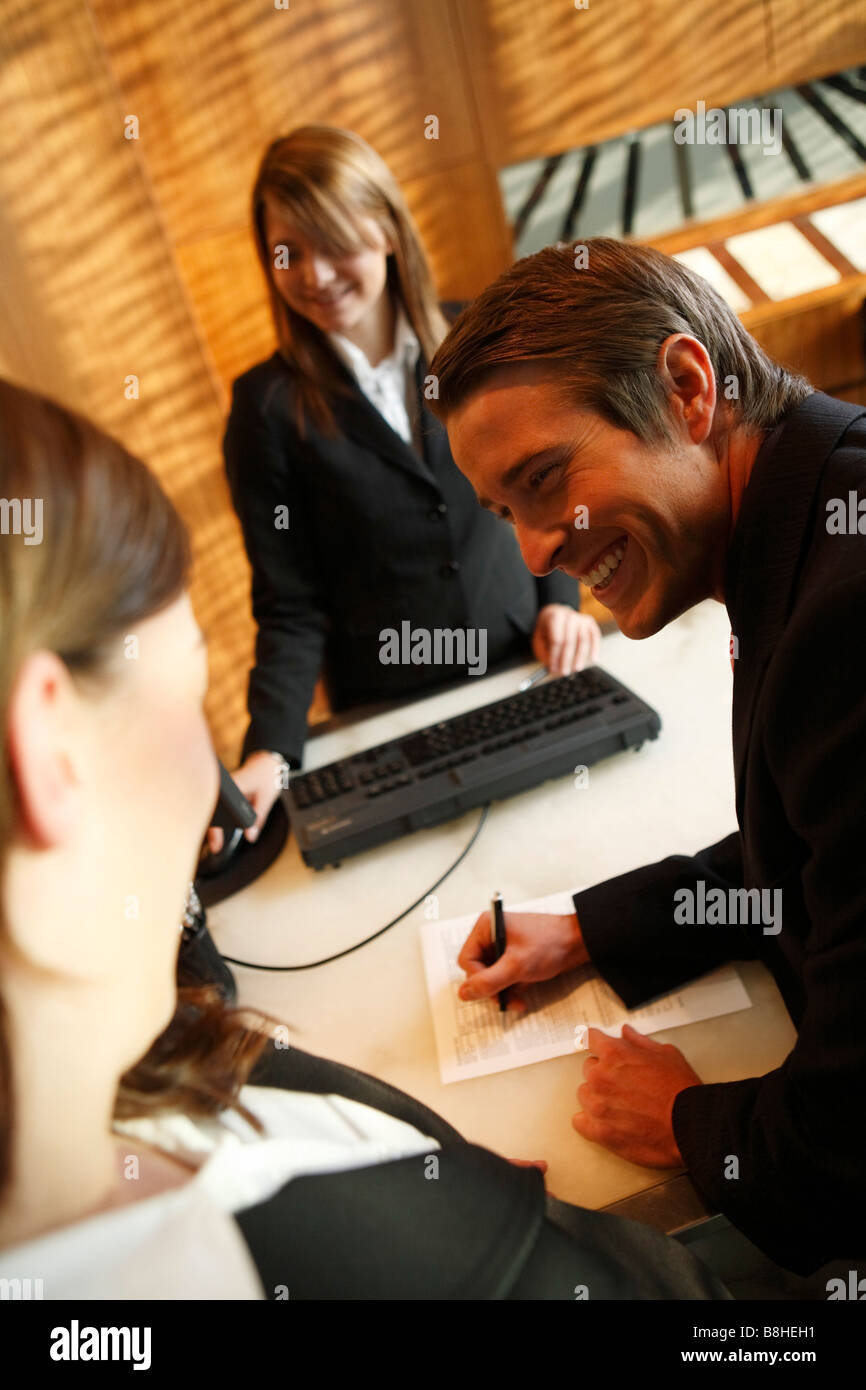 Man and woman checking into a hotel Stock Photo