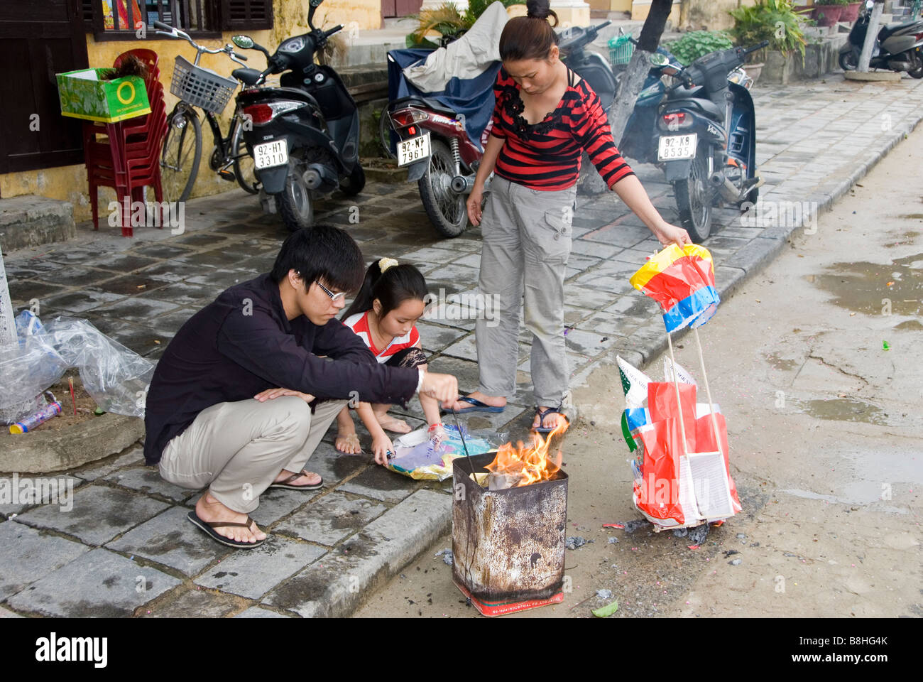Family burning offerings during Tet festival, Hoi An, Vietnam Stock Photo