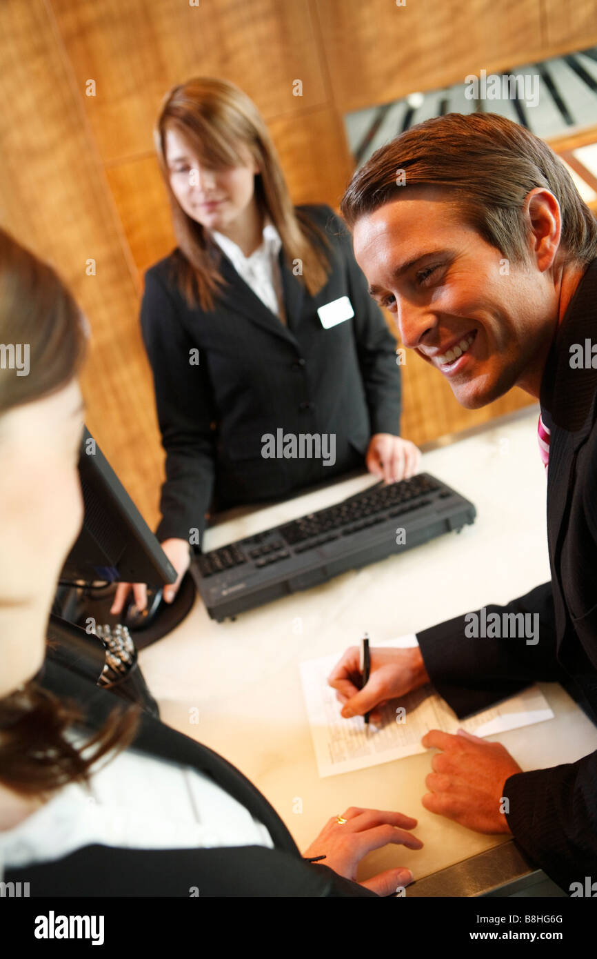 Man and woman checking into a hotel Stock Photo