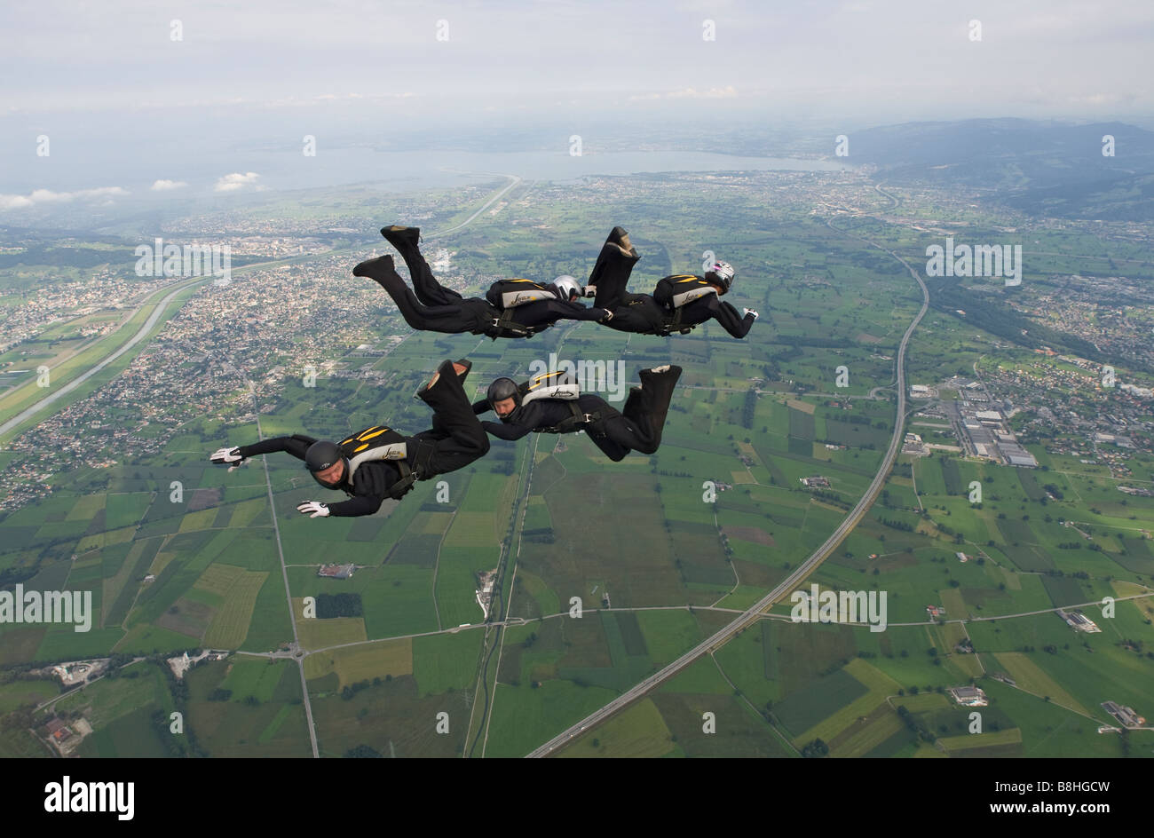 Skydiver team VIVA is flying a formation in the sky below clouds. 4-way ...