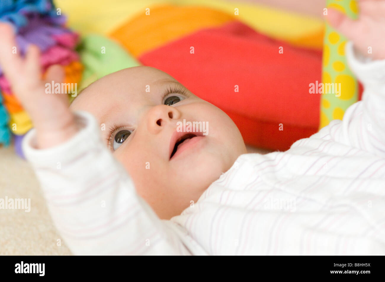 Happy baby playing lying on floor Stock Photo