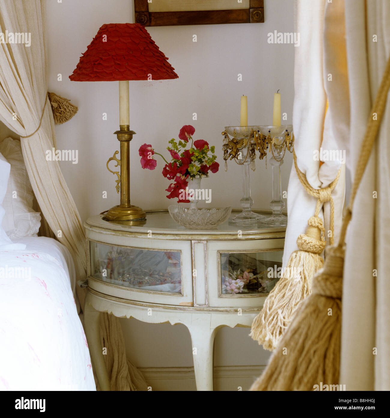 Detail of small circular glass fronted display table used as a bedside table Stock Photo