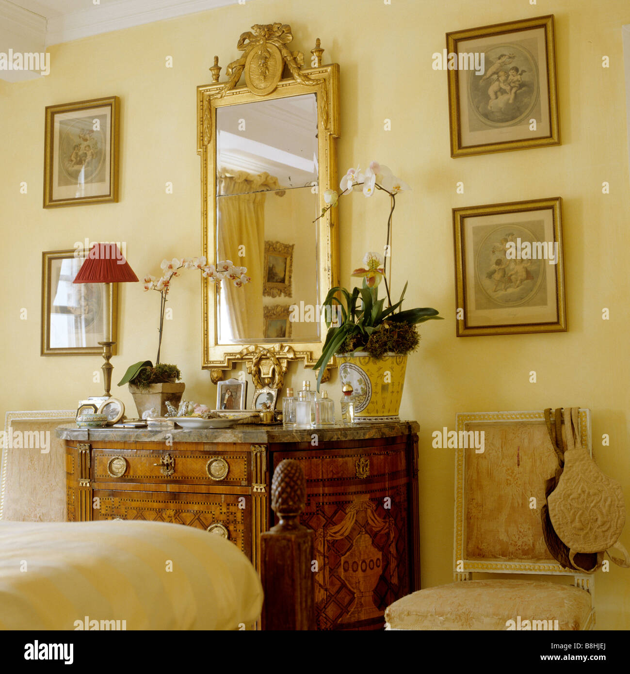 View of bedroom with marbletopped inlaid chest of drawers and a gilded