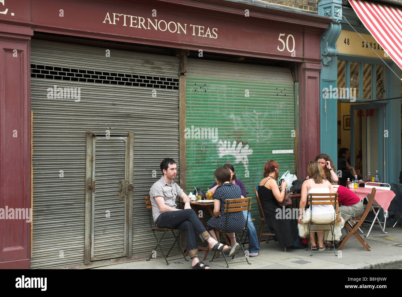 People sitting outside cafe in Spitalfields East End of London Stock Photo