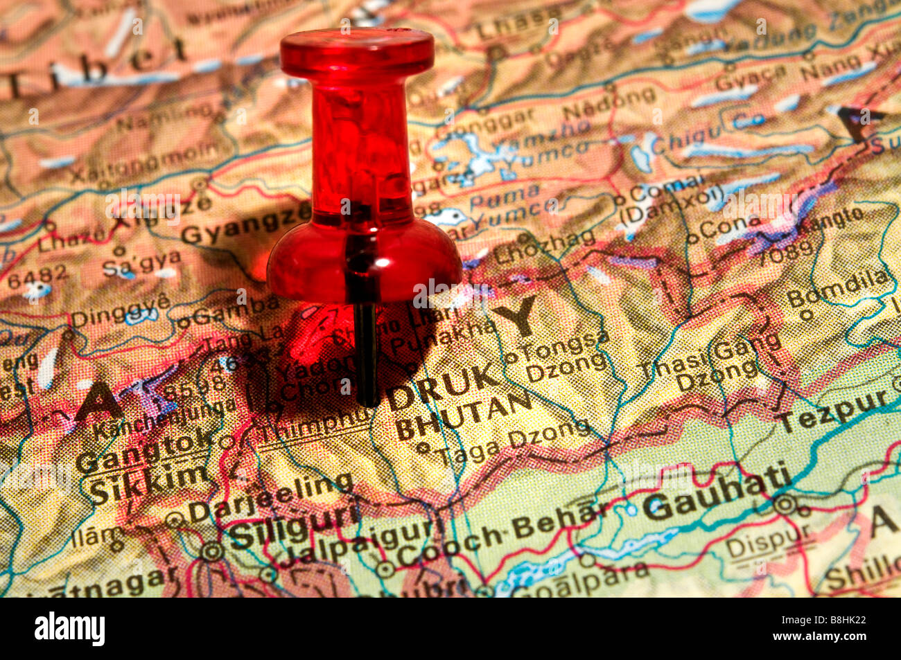 Red Pushpin on an atlas Bhutan Stock Photo