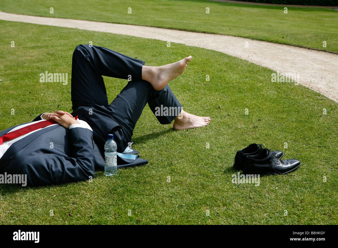 Businessman relaxing in the park barefoot Stock Photo - Alamy