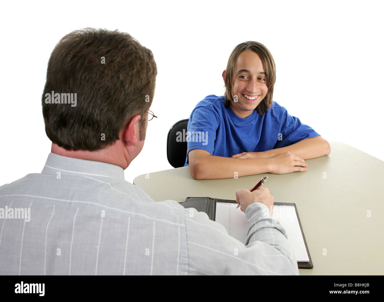 A student smiling during a conference with his teacher Stock Photo - Alamy