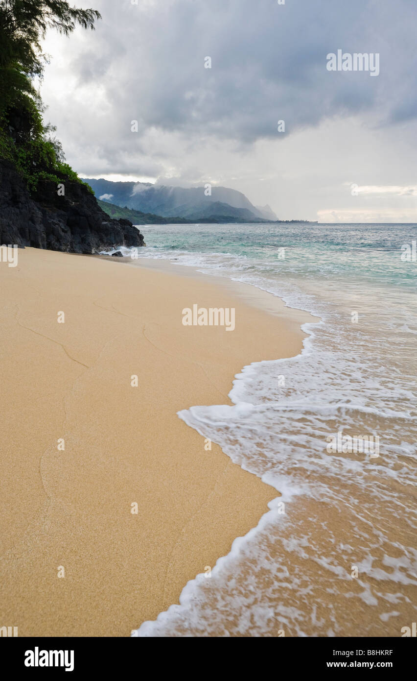 A stormy view of Hidden Beach with the Na Pali coast in the background on the North Kauai coast Hawaii Stock Photo