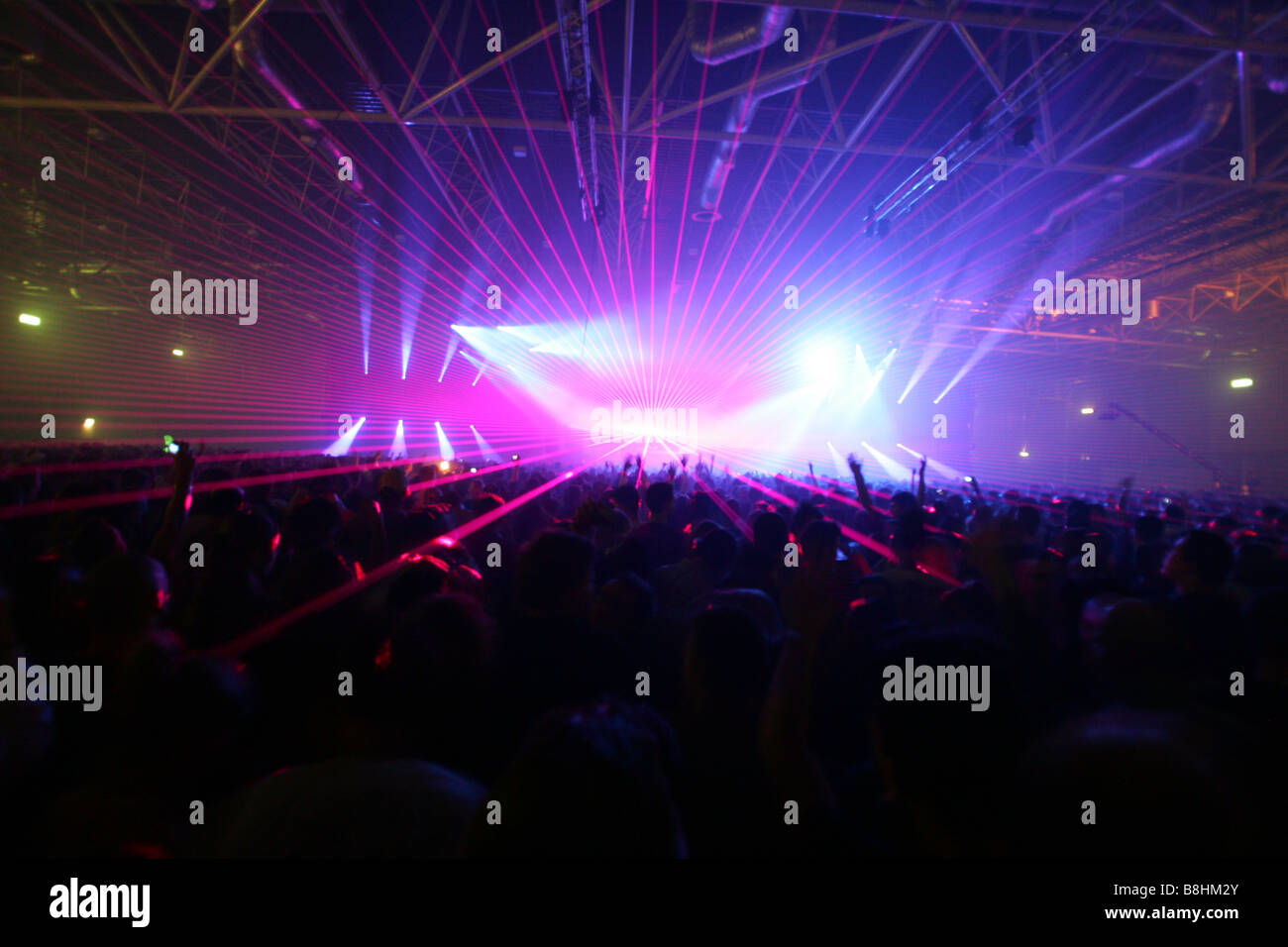Large crowd and colorful lights and lasers at a houseparty in the