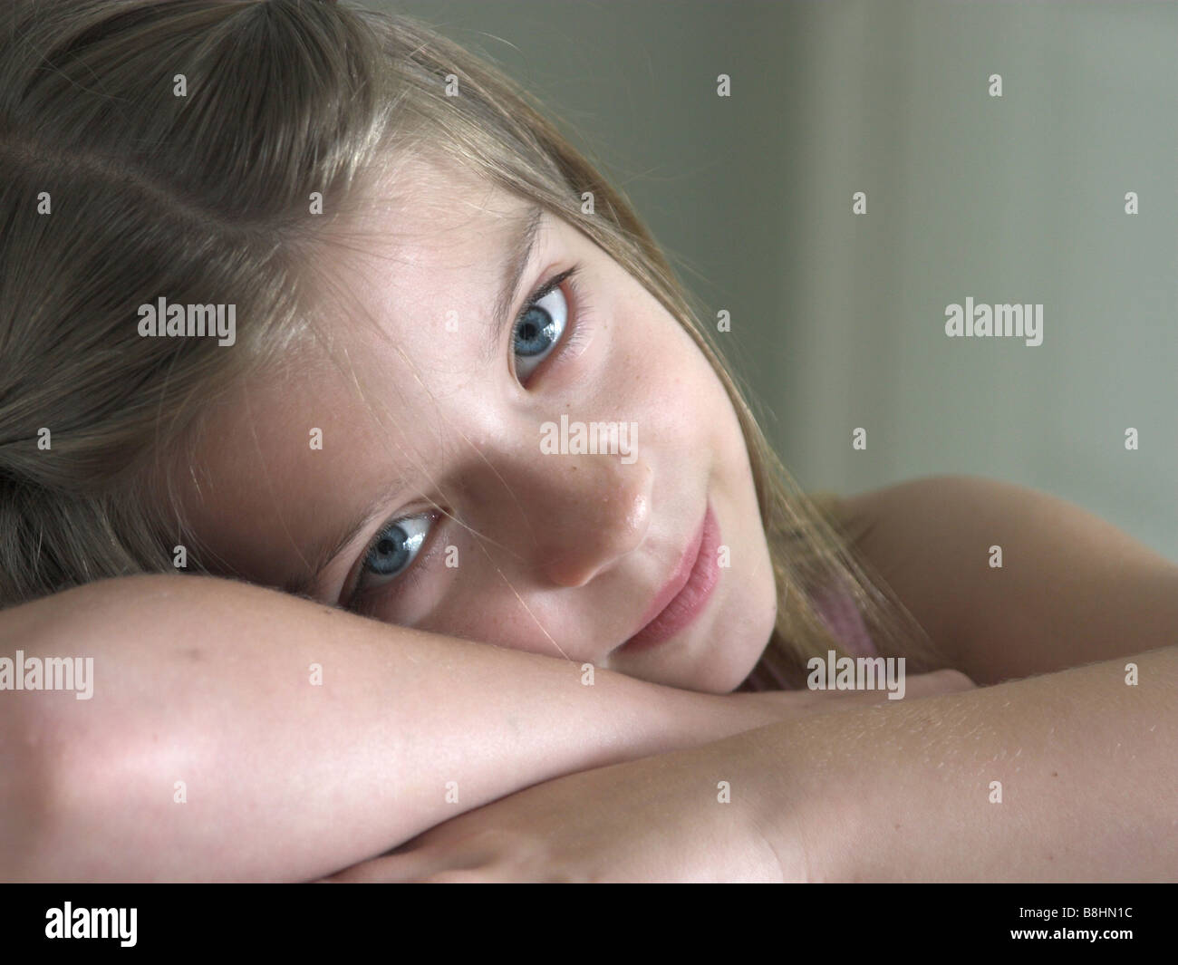 a pretty little girl resting her head on her hands Stock Photo - Alamy