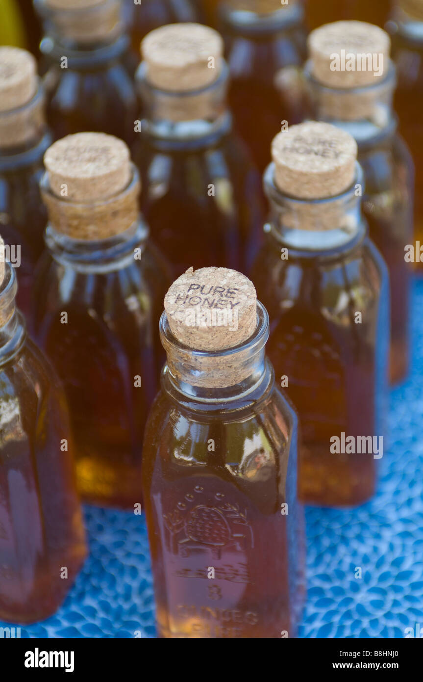Bottles of pure honey arranged for sale at a local farmer s market in