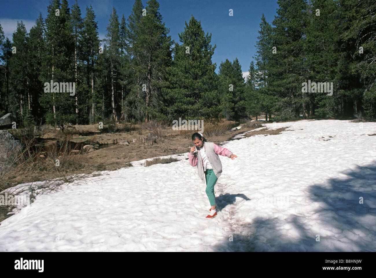 girl 12 years old walking in snow at Donner Memorial State Park California Stock Photo