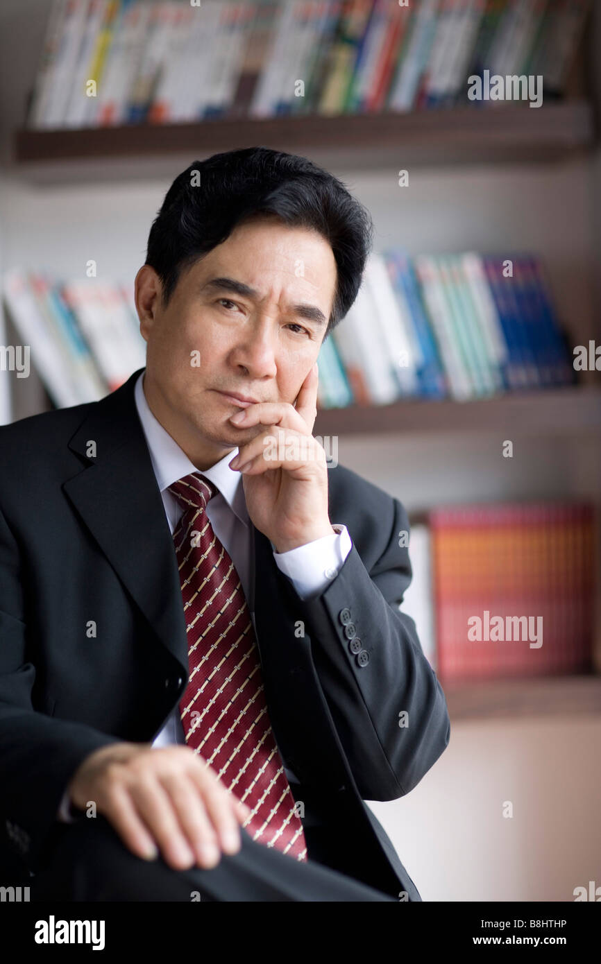 Businessman sitting on chair thinking in office Stock Photo - Alamy