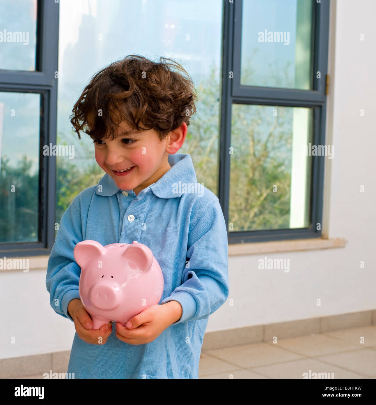 young boy holding a piggy bank Stock Photo - Alamy