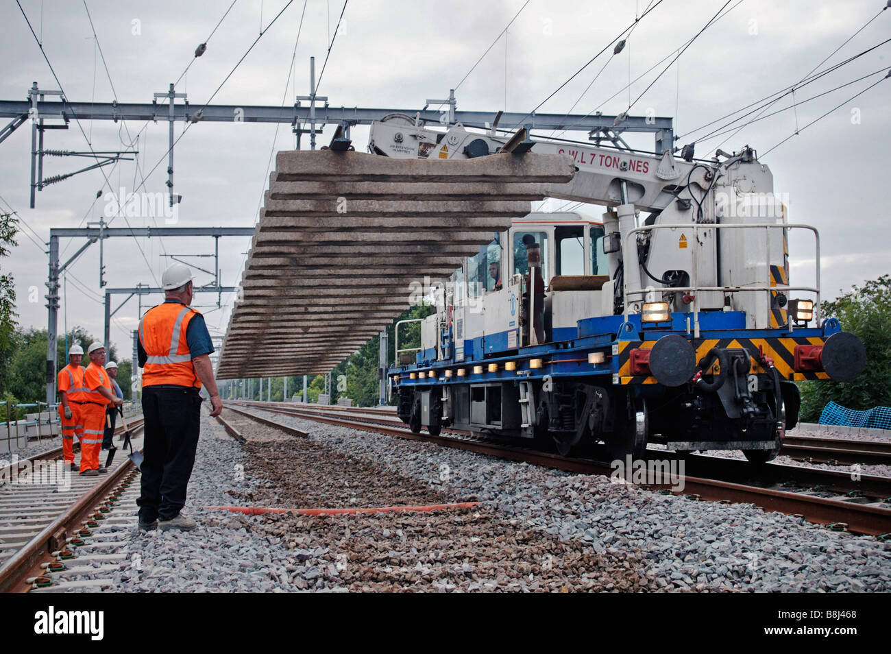 Selfpropelled twinjib railway crane lifting heavy section of