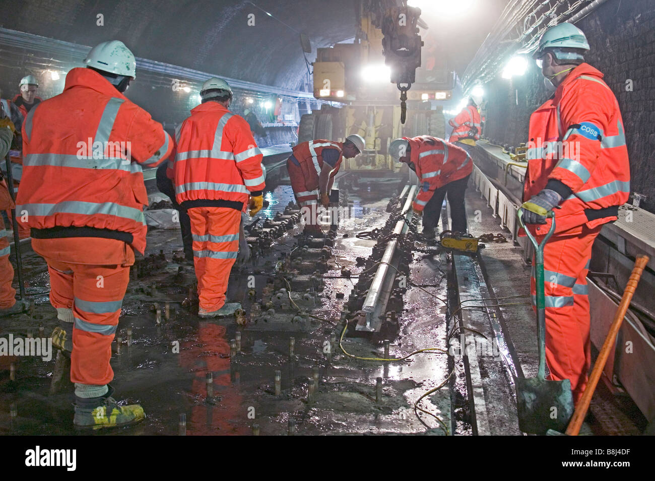Rail contractors removing worn-out rails during tunnel trackwork replacement project on a busy city railway. Stock Photo