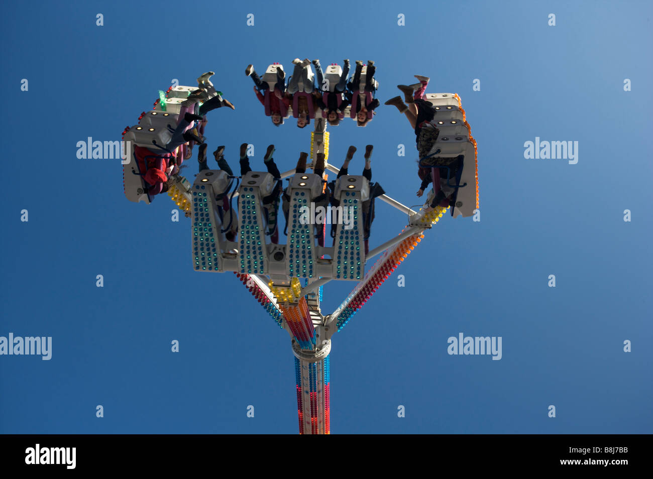 People riding an amusement park ride in bright sunshine Stock Photo - Alamy