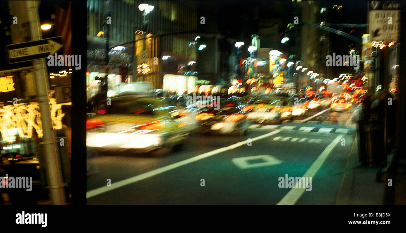 New York City street scene at night, with moving yellow taxi Stock ...