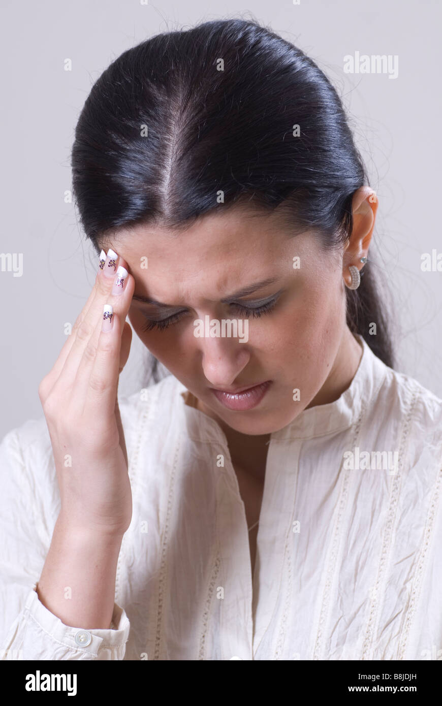 Woman hand on forehead in pain Stock Photo