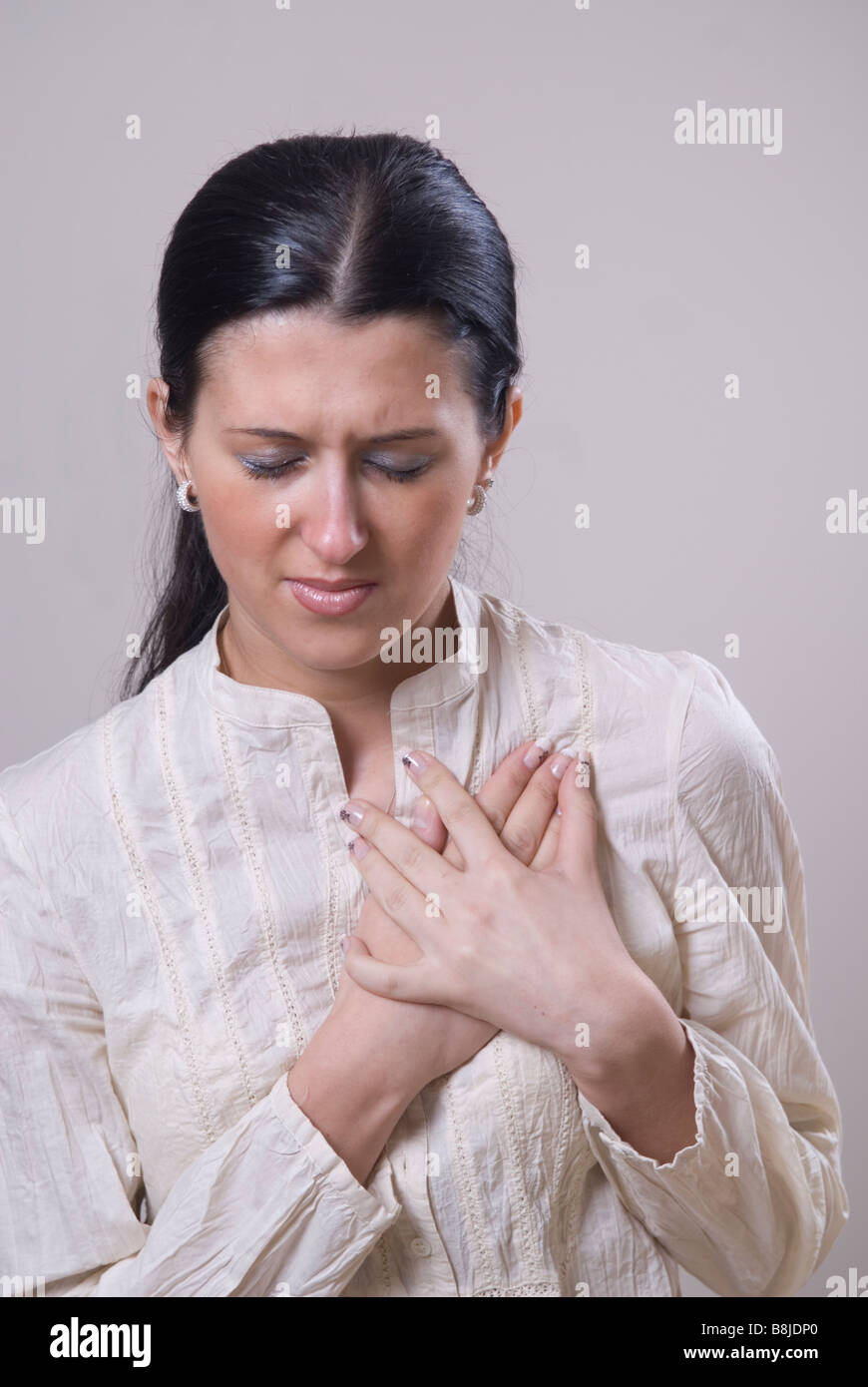 Young woman hands over heart Stock Photo