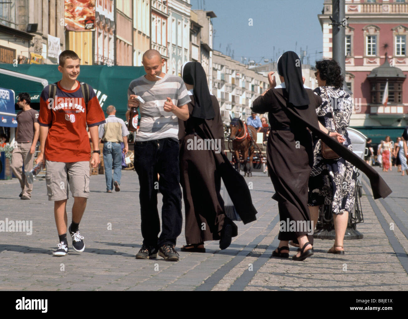 Young men and nuns strolling at Rynek (Market Square) in Wroclaw, Poland Stock Photo