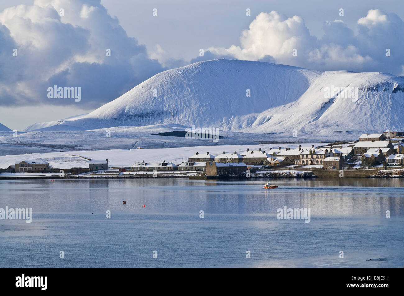 dh Harbour STROMNESS ORKNEY Fishingboat leaving harbour winter snow white hills landscape scenery Stock Photo