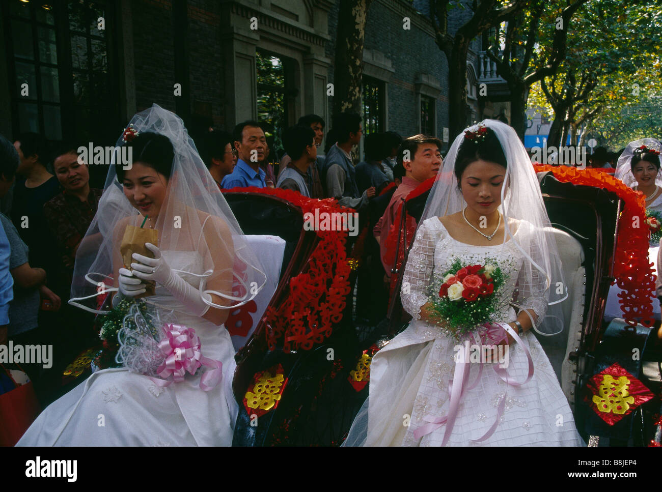 Group wedding Two brides women in white dresses with veils One behind  Seated in red rickshaws People SHANGHAI CHINA Stock Photo - Alamy