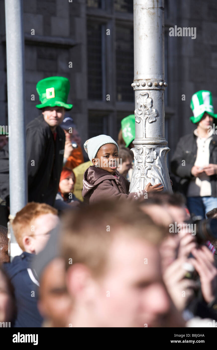 Onlookers enjoy the spectacle of the St Patricks Day Parade in sunshine in Dublin Ireland with a small boy in the centre Stock Photo