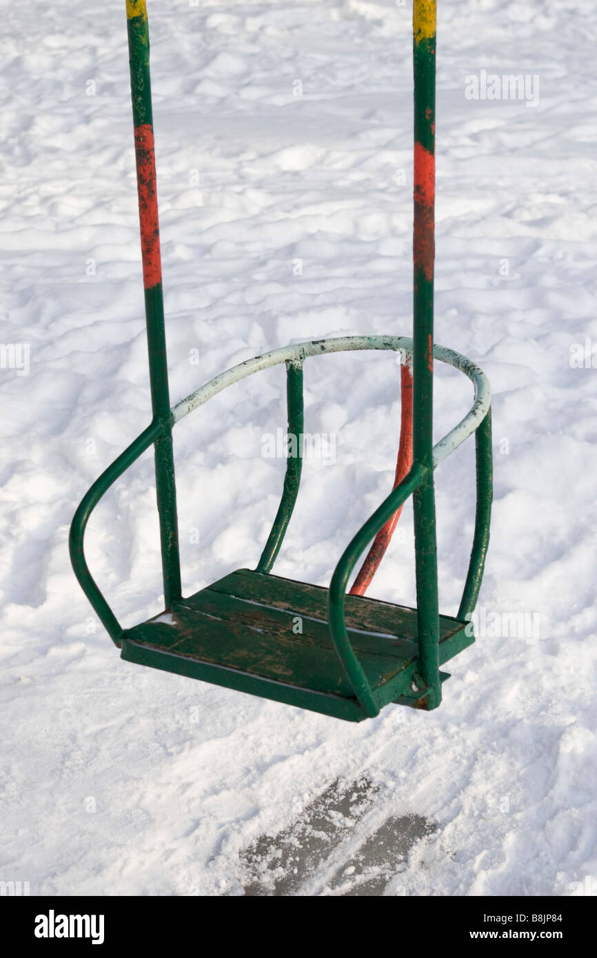 Multicolour painted swings on winter playground. Stock Photo