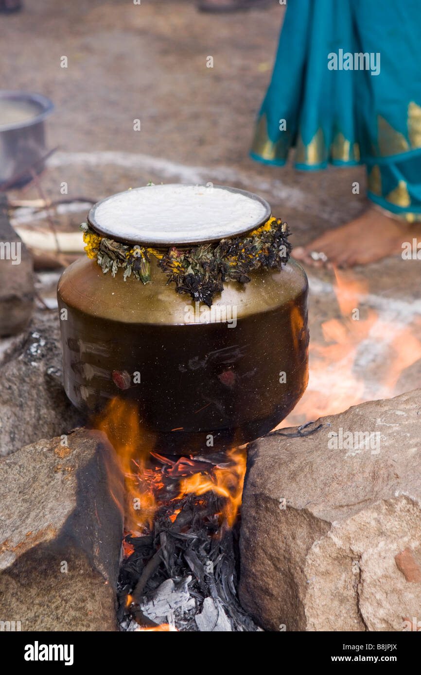 India Tamil Nadu Madurai Thiruchuli Village harvest festival cooking Pongal in brass pot on open fire Stock Photo