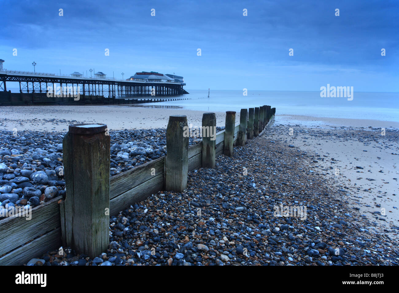 Cromer pier, beach groyne, at dawn looking down the beach to the sea, Norfolk, East Anglia, UK Stock Photo
