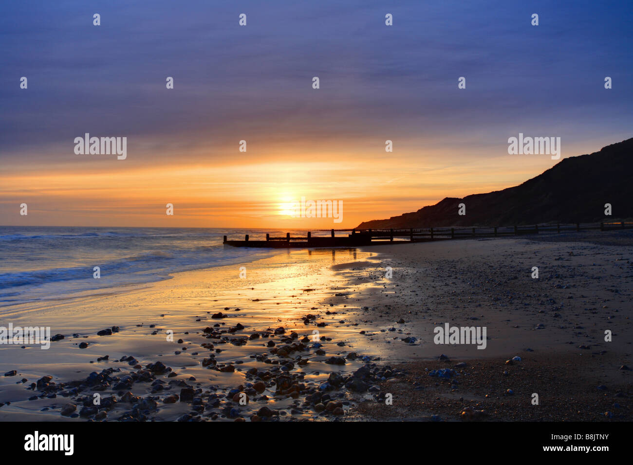 Cromer Sunrise Looking towards Overstrand, beach with the sun rising over the sea, North Norfolk, East Anglia, England. Stock Photo