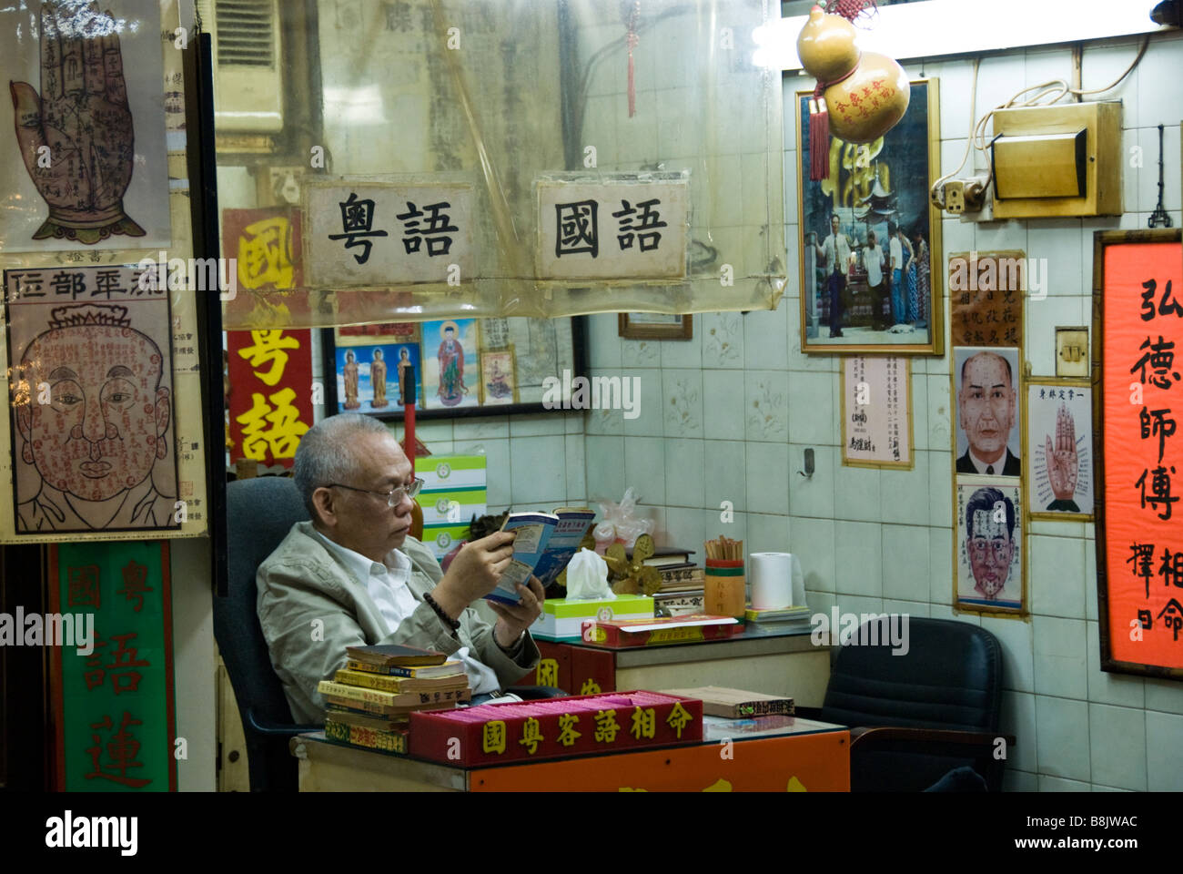 Fortune teller reading in his shop beneath Wong Tai Sin Temple, Hong
