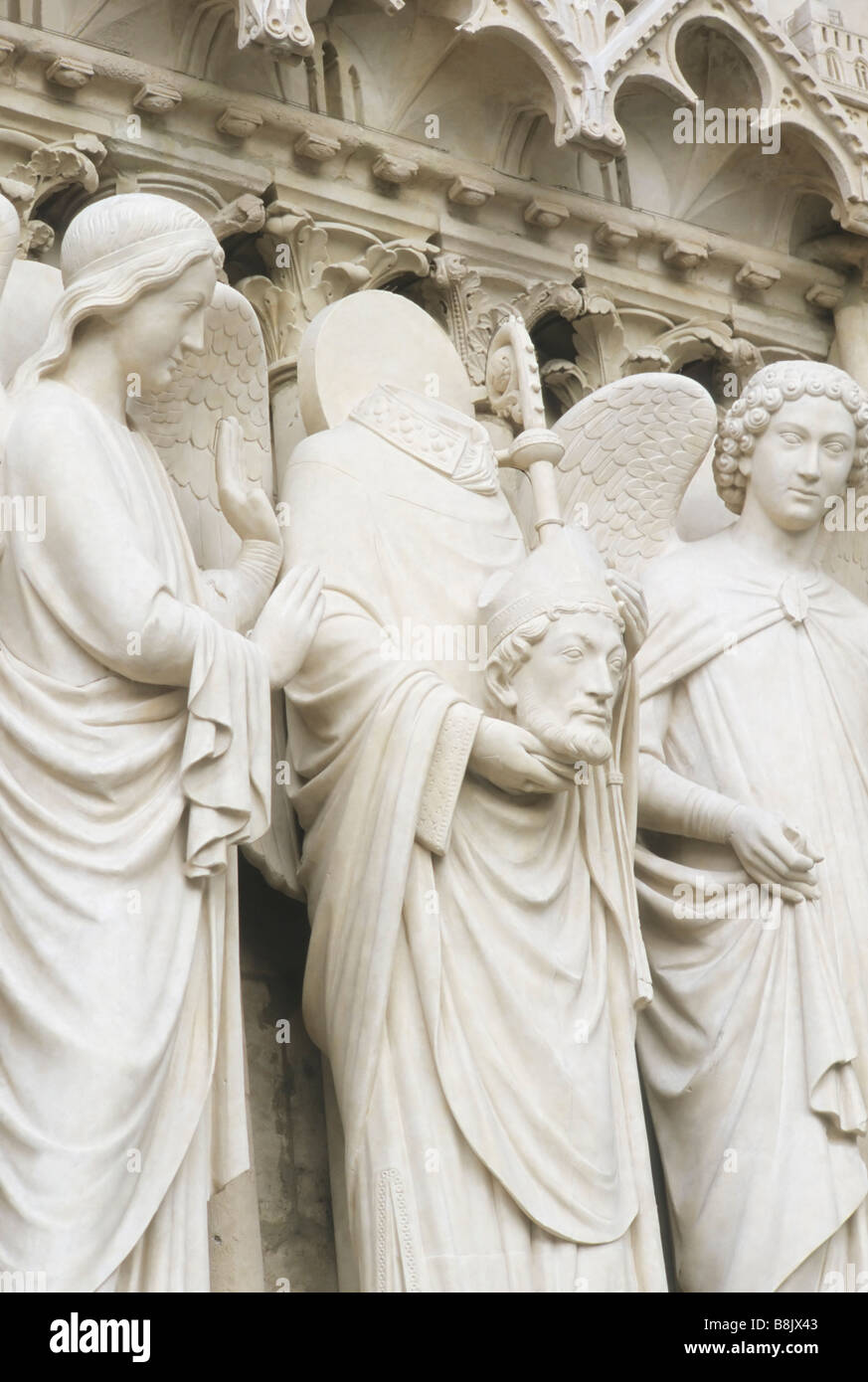 Saint Denis holding his head, flanked by two angels, left jamb of the Portal of The Virgin, Notre Dame, Paris France Gothic Stock Photo