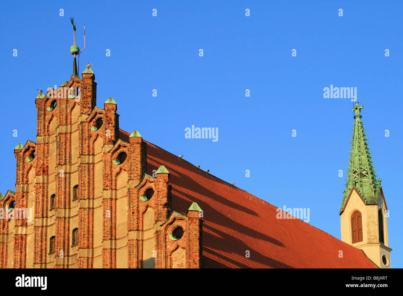 Sunset rays cast shadows on the roof of St. John's Church, in Riga ...