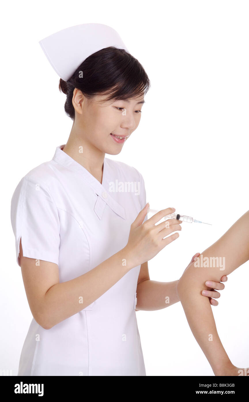 Nurse giving an injection to a patient Stock Photo