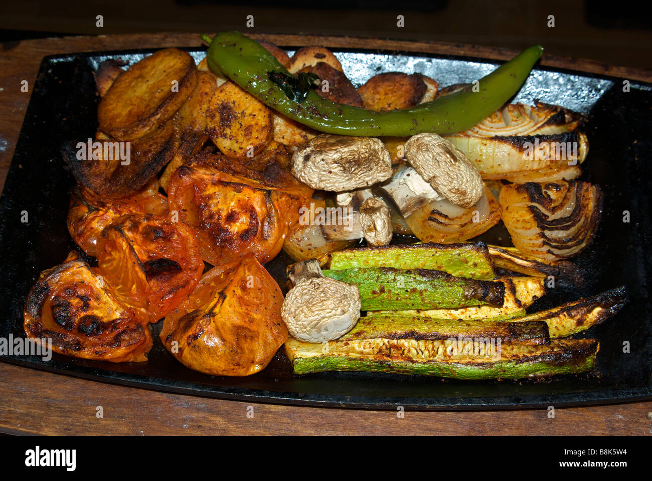 Mixed grilled vegetables in hot cast iron pan Stock Photo