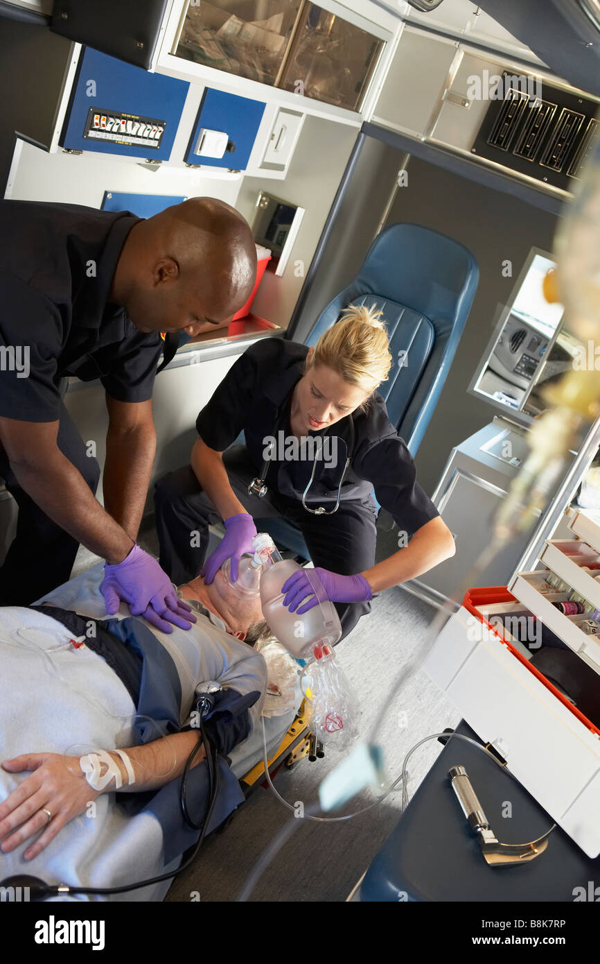 Paramedics performing CPR on patient in ambulance Stock Photo