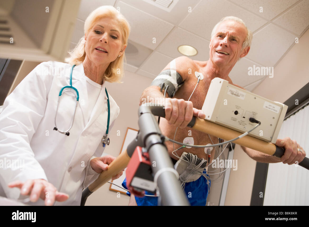 Doctor With Patient While They Run Being Monitored Stock Photo