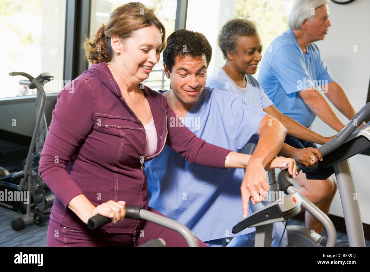 Nurse With Patient In Rehabilitation Using Exercise Machine Stock Photo