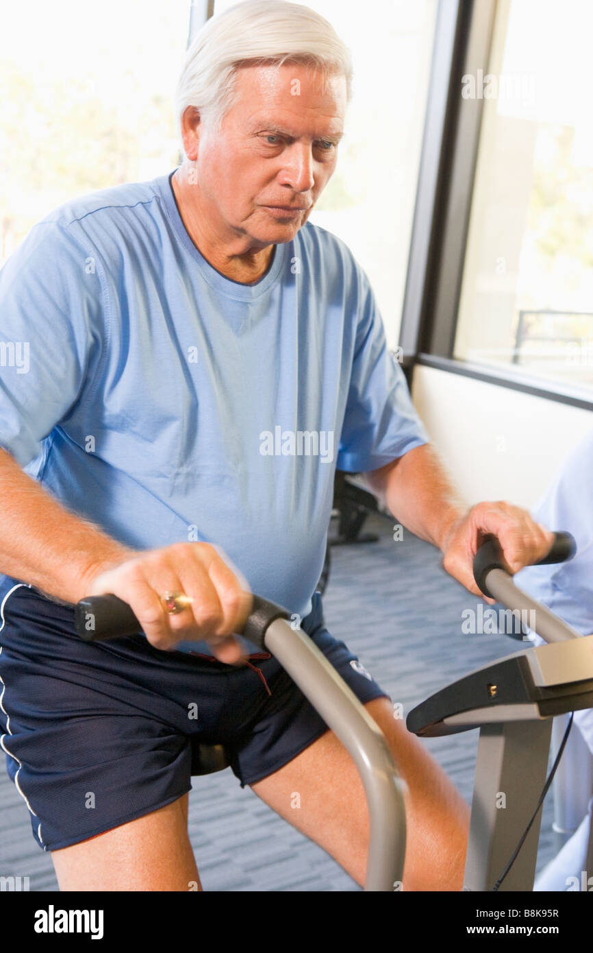 Patient Working Out On Exercise Machine Stock Photo