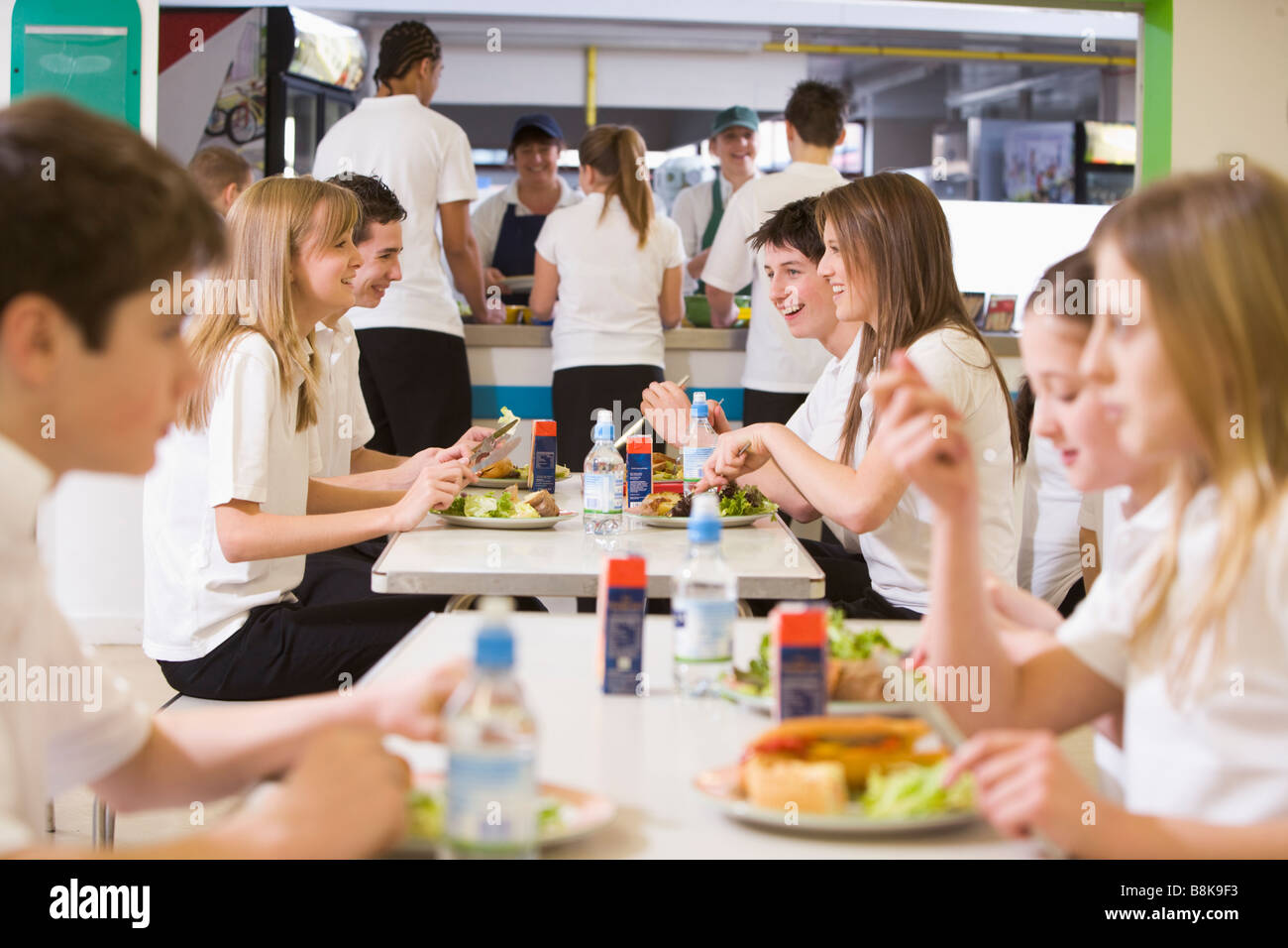 Students having lunch in dining hall Stock Photo
