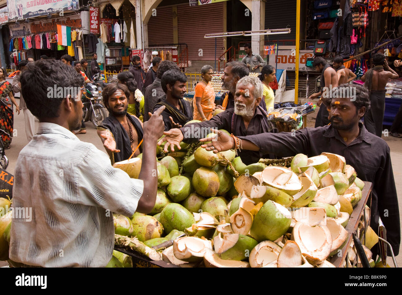 India Tamil Nadu Madurai Pongal Harvest Festival hindu pilgrims buying young coconuts to drink Stock Photo